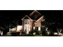 Night view of a two-story home with landscape lighting at 1325 Starboard Way, Cumming, GA 30041