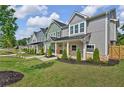 Three townhomes with gray and green siding, metal roofs, and a shared lawn at 702 Fairgate Rd, Marietta, GA 30064