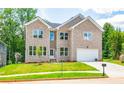 Two story brick home with a white garage door and landscaped lawn at 5649 Eagles Watch, Douglasville, GA 30135