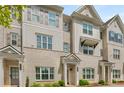 Beige brick townhome with gray shutters, white columns, and landscaping at 1708 Evenstad Way, Smyrna, GA 30080