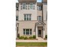Beige brick townhome with gray shutters, white columns, and landscaping at 1708 Evenstad Way, Smyrna, GA 30080