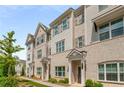 Row of beige brick townhomes with gray shutters and white columns at 1708 Evenstad Way, Smyrna, GA 30080