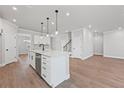 Bright open concept kitchen showcasing stainless steel appliances, a kitchen island, and wood flooring at 313 Foxglove Way, Mcdonough, GA 30253