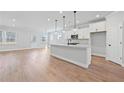 A bright kitchen with white cabinets, a large island with pendant lighting, and stainless steel appliances at 313 Foxglove Way, Mcdonough, GA 30253