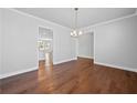 Elegant dining room featuring hardwood floors, crown molding, and modern chandelier lighting fixture at 236 Begonia Way, Mcdonough, GA 30253