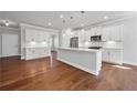Spacious kitchen featuring white cabinets, stainless steel appliances, and a large center island with pendant lighting at 236 Begonia Way, Mcdonough, GA 30253