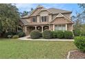 Attractive two-story home featuring a stone and siding facade, lush green lawn, and manicured landscaping at 5669 Hollowbrooke Nw Ln, Acworth, GA 30101