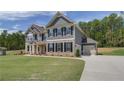 Two-story home with gray siding, brick accents, and a landscaped lawn at 62 Homesite Cooper W Cv, Fayetteville, GA 30215