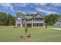 Two-story home with gray siding, brick accents, and a landscaped lawn at 62 Homesite Cooper W Cv, Fayetteville, GA 30215