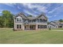 Two-story home with gray siding, brick accents, and a landscaped lawn at 62 Homesite Cooper W Cv, Fayetteville, GA 30215