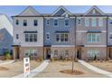 Three-story townhouses with brick and siding, landscaping, and sidewalks; new homes sign at 1238 Ainsworth Aly # 38, Sugar Hill, GA 30518