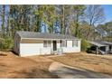 Front yard view of a freshly painted white house with a carport at 3563 Bolfair Nw Dr, Atlanta, GA 30331