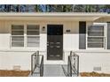 Front entrance with black door, gray stone, and black railings at 3563 Bolfair Nw Dr, Atlanta, GA 30331