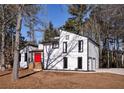 Modern home with a white facade, black trim, and a striking red front door at 2645 Shadow Woods Ne Cir, Marietta, GA 30062
