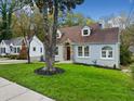 Cute bungalow with gray brick exterior, landscaped lawn, and mature trees at 1183 Cahaba Dr, Atlanta, GA 30311