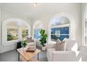 Bright sunroom with arched windows, comfortable seating, and lush plants at 1183 Cahaba Dr, Atlanta, GA 30311