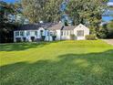 Charming white brick ranch house with gray shutters, and a large green lawn at 1641 Pinehurst Sw Dr, Atlanta, GA 30311