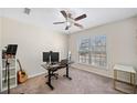 Bright bedroom features a ceiling fan, a desk with computer setup, and ample natural light at 522 Spring View Dr, Woodstock, GA 30188
