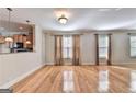 Hardwood floor living room with wall-to-wall windows and neutral decor at 2790 Laurel Valley Trail, Buford, GA 30519