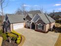 Brick home with landscaping, large driveway, and two-car garage at 5008 Cambridge Ln, Villa Rica, GA 30180