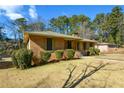 Brick ranch house with a landscaped lawn and mature trees at 750 Skipper Dr, Atlanta, GA 30318