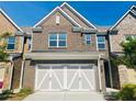 Brick front of townhome featuring a 2-car garage at 1216 Foxcroft Ln, Cumming, GA 30041