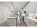 Bright kitchen featuring white cabinets, stainless steel appliances, pendant lighting, and a center island at 396 Pratt Se Dr # 1932, Atlanta, GA 30315