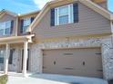 Two-car garage with decorative hardware and brick facade at 2338 Newbury Oaks Dr, Lawrenceville, GA 30044