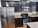 Modern kitchen with stainless steel appliances and dark cabinets at 2338 Newbury Oaks Dr, Lawrenceville, GA 30044