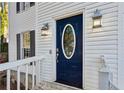 Blue front door with glass oval window and white frame at 1741 Charrington Way, Powder Springs, GA 30127