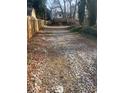 Long gravel driveway lined with wooden fences and overgrown trees on either side at 2025 Moody Sw Dr, Atlanta, GA 30315