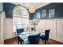 Formal dining room with a glass table and blue velvet chairs at 110 Golf Terrace Dr, Stockbridge, GA 30281