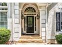 Elegant front entrance with a black door and stone steps at 110 Golf Terrace Dr, Stockbridge, GA 30281