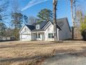 White farmhouse exterior with gray roof, two-car garage, and landscaped yard at 4392 Navajo Se Ln, Acworth, GA 30102