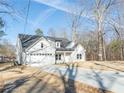 White farmhouse exterior with gray roof and a two-car garage at 4392 Navajo Se Ln, Acworth, GA 30102