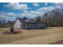 Inviting exterior featuring a long porch and neutral colors, creating a warm and welcoming atmosphere at 85 Woodfin Way, Social Circle, GA 30025