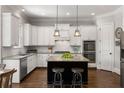 Modern kitchen features white cabinets, stainless steel appliances, granite countertops, and a center island with seating at 5330 Lake Redwine Nw Cv, Acworth, GA 30101