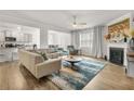 Open living room with kitchen view, featuring L-shaped sofa and hardwood floors at 2732 Piper Dr, Atlanta, GA 30331