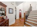 Elegant foyer showcases hardwood floors, a staircase, and a charming arched doorway at 4595 Carriage Walk Ln, Cumming, GA 30040
