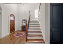 Bright foyer featuring hardwood floors, stairs, and an arched doorway at 4595 Carriage Walk Ln, Cumming, GA 30040