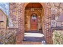 Inviting arched stone entryway with a wooden door and decorative lighting at 4595 Carriage Walk Ln, Cumming, GA 30040