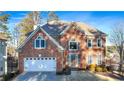 Two-story house with a brick exterior, white garage door, and manicured lawn at 2151 Lake Haven Way, Suwanee, GA 30024