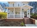 Charming home featuring a welcoming front porch with swing and beautiful landscaping at 110 Bowen Sw Cir, Atlanta, GA 30315