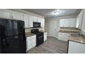 Kitchen boasts granite counters, white cabinets, and black appliances at 710 Ridge Way, Lithonia, GA 30058