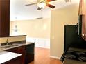 Kitchen features dark wood cabinets, black appliances, and granite countertops at 307 Creek Manor Way, Suwanee, GA 30024