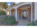 Inviting front porch with stone flooring and stately columns at 6320 Glen Oaks Ln, Sandy Springs, GA 30328