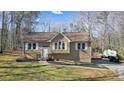 Tan house with white shutters, a wooden deck, and a landscaped yard at 15 Indian Woods Ne Dr, Rydal, GA 30171