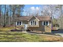 Tan house with white shutters, a wooden deck, and a landscaped yard at 15 Indian Woods Ne Dr, Rydal, GA 30171