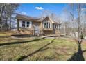 Tan house with white shutters, a wooden deck, and a grassy yard at 15 Indian Woods Ne Dr, Rydal, GA 30171