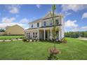Two-story home with brick and siding, a front porch, and landscaped lawn at 165 Poppy St, Mcdonough, GA 30253